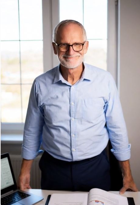 Ed at his desk — still in the work, on his terms